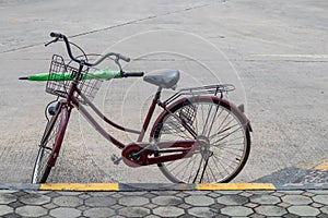 Old bicycle and umbrella in a basket on the road