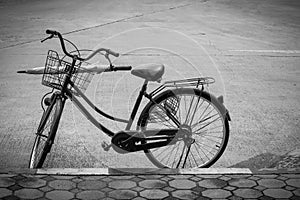 Old bicycle and umbrella in a basket on the road