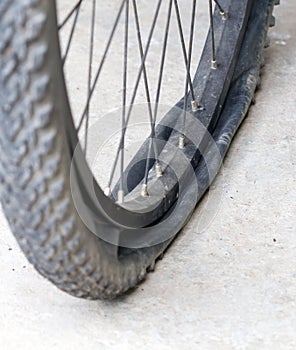 Old Bicycle wheel with flat tyre on road