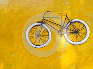 Old bicycle and yellow cement wall