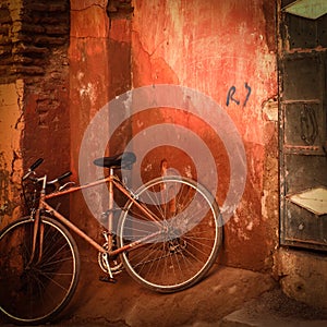 Old bicylce in front of grungy red wall