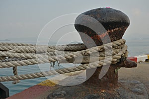 Old big cleat with ropes to hold a ship