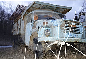 An old and big truck or car, with alot of rust photo