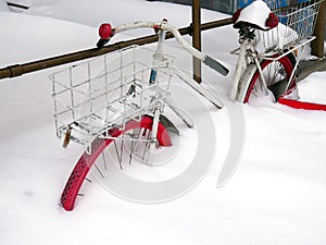 The old bike is covered with snow