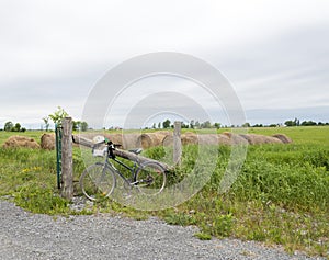 Old bike leaning against a wooden post fence on a farm