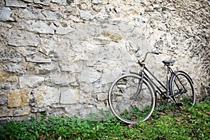 Old bike standing in front of old stone wall