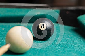 Old billiard ball 8 on a green table. billiard balls isolated on a green background