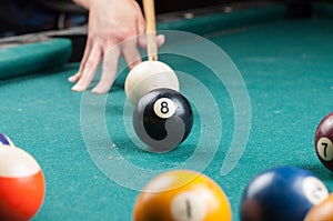 Old billiard ball 8 and stick on a green table. billiard balls isolated on a green background