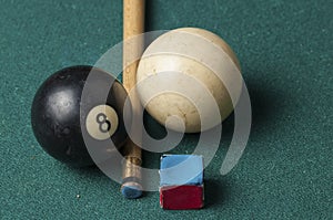 Old billiard ball 8 and stick on a green table. billiard balls isolated on a green background.Black and white