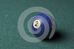 Old billiard ball number 2 blue color on green billiard table, copy space