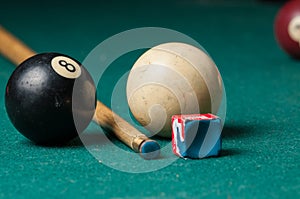 Old billiard ball 8 and stick on a green table. billiard balls isolated on a green background.Black and white photo