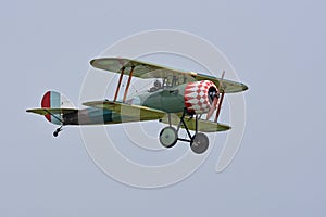 Old biplane in flight with blue sky in background