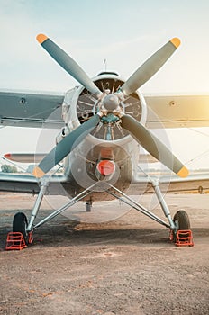 Old biplane, turboprop aircraft in the parking lot.