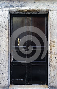 Old black door with bronze pull handle