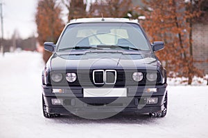 Old, black, German family car front view in winter