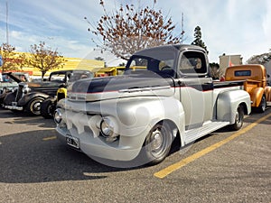 Old 1950s Ford F 6 V8 cargo pickup truck in a parking lot.