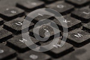 old black keyboard with keys covered in dust and dirt isolated on white background