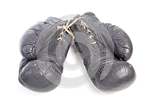 Old black leather boxing gloves isolated on white background with shadows lying on flat surface