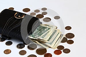 Old black leather purse with us dollars bill and coin on a white background with copy space,selective focus