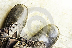 Old black leather shoes on the floor. Pair of old dirty black leather shoes