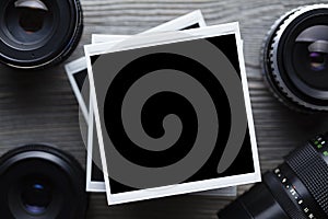 Old black lenses and classic photo frames on wooden background