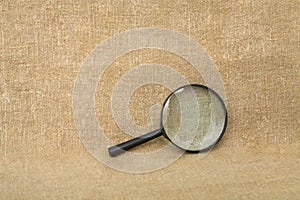 Old black magnifier on drapery background