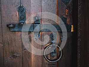Old black metal deadbolt on a wooden door photo