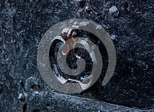 Old black metal knob of an old door in aged medieval castle