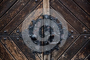 Old black metal knob of an old door in aged medieval castle