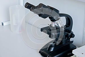 Old black microscope isolated on white background