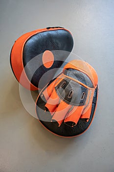 Old black and orange boxing gloves on grey concrete background