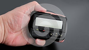 Old black pager in hand