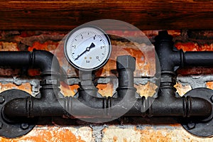 Old black pipeline and pressure gauge