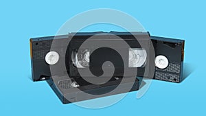 old black plastic VHS video cassette with on a blue surface against blue background