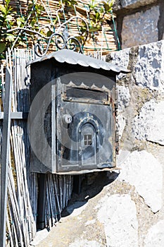 Old black Poste Italiane mailbox on grey grungy wall in Capri, Italy photo