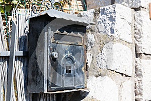 Old black Poste Italiane mailbox on grey grungy wall in Capri, Italy photo