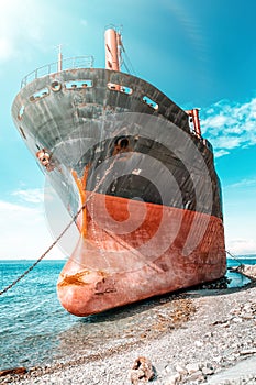 An old black-and-red ship that anchored and ran aground. The bow of the ship close-up. View from the bow of the ship. Blue Sea and