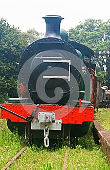 OLD BLACK AND RED STEAM LOCOMOTIVE ABANDONED ON AN UNUSED RAIL