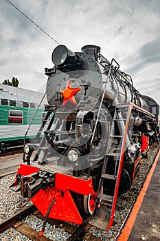 Old black steam locomotive on railway station