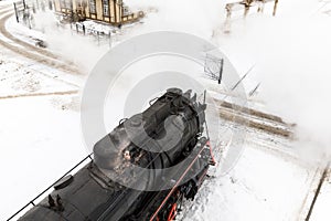 Old black steam locomotive in Russia in the winter on a background of snow
