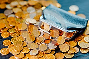 An old black wallet sits on top of a pile of Russian coins. The concept of inflation and poverty.