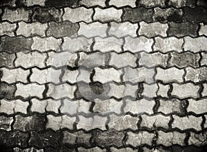 Old black and white concrete paving blocks shameless pattern background. Pavement texture.