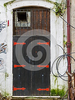 old black wooden door with red metal dashes