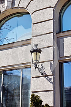 Old black wrought iron street lamp on wall