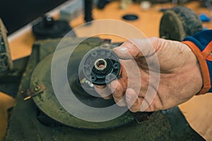 Old blade disc bearing on motorized robotic lawnmower. dirty and rusty lawnmover blade ready to be replaced by a new one