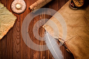 Old blank antique scroll paper on table with quill pen and candle