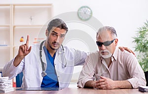 Old blind man visiting young male doctor