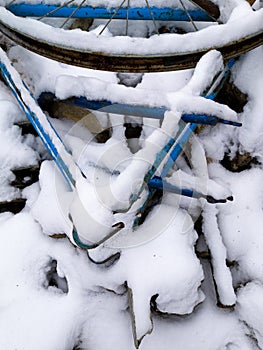 Old blue bike covered with white and cold snow. Old bicycle covered with snow