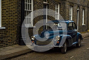 Old blue car parked on the street, old london, old building in l