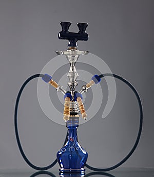 An old blue ceramic hookah on a grey background